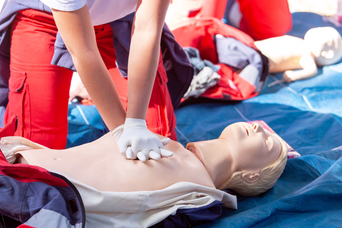 Group of Students Watching an OFA Instructor performing Chest Compressions on a Dummy.